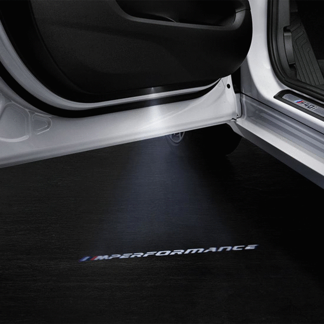 63312456413 - Retrofitting / Conversion / Accessories: M Performance Logos Led Door Projector for BMW: 128i, 135i, 228i, 228iX, 230i, 230iX, 320i, 320iX, 323i, 325i, 325xi, 328d, 328dX, 328i, 328iX, 328xi, 330e, 330i, 330iX, 330xi, 335d, 335i, 335is, 335iX, 335xi, 340i, 340iX, 428i, 428iX, 430i, 430iX, 435i, 435iX, 440i, 440iX, 525i, 525xi, 528i, 528iX, 528xi, 530e, 530eX, 530i, 530iX, 530xi, 535d, 535dX, 535i, 535iX, 535xi, 540dX, 540i, 540iX, 545i, 550i, 550iX, 640i, 640iX, 645Ci, 650i, 650iX, 740eX, 740i, 740iX, 740LdX, 740Li, 740LiX, 745eX, 745i, 745Li, 750i, 750iX, 750Li, 750LiX, 760i, 760Li, 840i, 840iX, BMW ALPINA B6, BMW ALPINA B7, BMW ALPINA B7L, BMW ALPINA B7LX, BMW ALPINA B7X, Hybrid 3, Hybrid 5, Hybrid 7, Hybrid 7L, Hybrid X6, M Coupé, M2, M2 Competition, M2 CS, M235i, M235iX, M240i, M240iX, M3, M4, M4 CS, M4 GTS, M5, M550iX, M6, M760iX, M8, M850iX, X1 28i, X1 28iX, X1 35iX, X2 28i, X2 28iX, X2 M35iX, X3 2.5i, X3 28dX, X3 28i, X3 28iX, X3 3.0i, X3 3.0si, X3 30eX, X3 30i, X3 30iX, X3 35iX, X3 M, X3 M40iX, X4 28iX, X4 30iX, X4 35iX, X4 M, X4 M40iX, X5 3.0si, X5 3.5d, X5 35dX, X5 35i, X5 35iX, X5 4.8i, X5 40eX, X5 40i, X5 40iX, X5 45eX, X5 50iX, X5 M, X5 M50iX, X6 35i, X6 35iX, X6 40i, X6 40iX, X6 50iX, X6 M, X6 M50iX, X7 40iX, X7 50iX, X7 M50iX, Z4 2.5i, Z4 28i, Z4 3.0i, Z4 3.0si, Z4 30i, Z4 35i, Z4 35is, Z4 M3.2 Image image