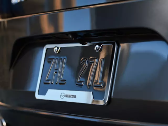 C9N3V4027 - Exterior: License Plate Frame, Polished, Mazda Logo for Mazda: 2, 3, 5, 6, CX-3, CX-30, CX-5, CX-7, CX-9, MPV, MX-5 Miata, RX-8, Tribute Image